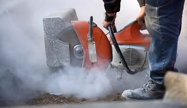 worker using a cement cutter